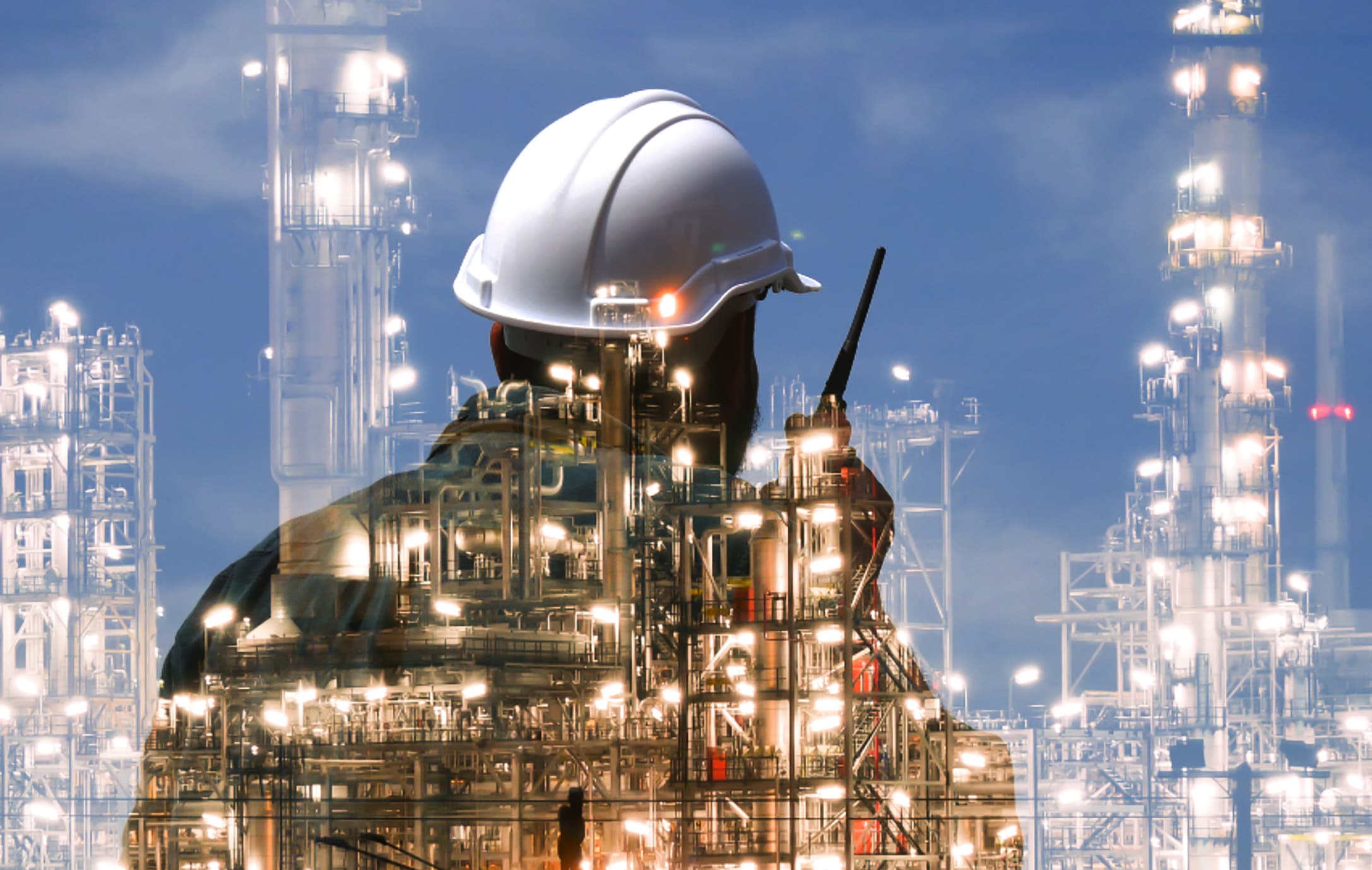 Double-exposed image of a worker in a hardhat and a power plant. The worker is using an RCA two-way radio for safety.