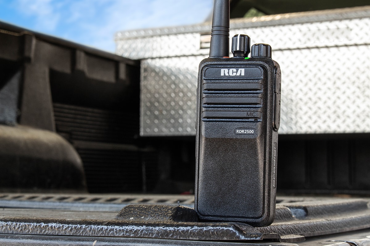 An RCA RDR2500 portable two-way radio is set upright in the bed of a pickup truck.